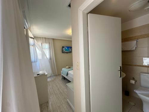 a bathroom with a toilet and a bed in a room at Theasis Athens in Athens