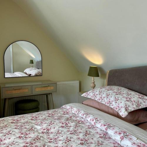 a bedroom with a bed and a mirror at River View Cottage in Newton Stewart