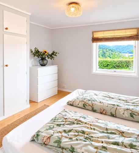 a bedroom with a bed and a window at Jåsund SunView in Lyngdal