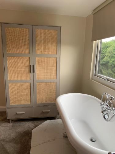 a white bath tub in a bathroom with a window at River View Cottage in Newton Stewart