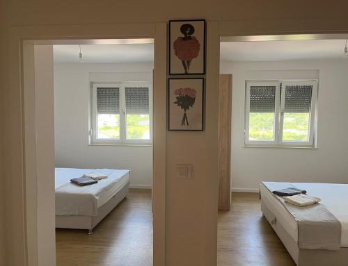 a room with two beds and two windows at SunnyOasis in Mostar