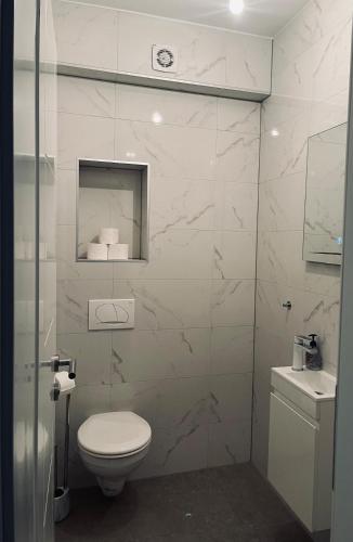 a white bathroom with a toilet and a sink at SunnyOasis in Mostar