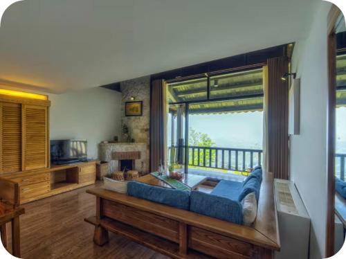 a living room with a blue couch and a large window at Joy Villa Sapa in Sapa