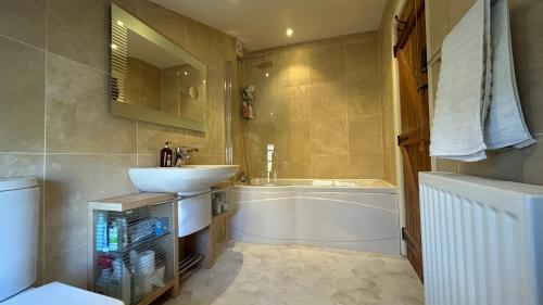 a bathroom with a sink and a tub and a toilet at Tarn House in Hawes