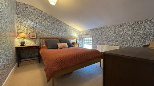 a bedroom with a bed in a room with wallpaper at Tarn House in Hawes
