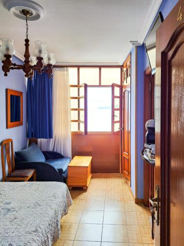 a bedroom with a bed and a couch and a window at Hotel Imperial in Tazones