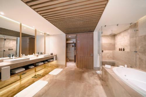 a bathroom with two sinks and a bath tub and a tubermott at Grand Velas Boutique Hotel in San José del Cabo