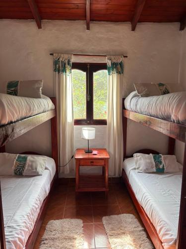 a room with three bunk beds and a window at El Paso Ibera Cabañas in Colonia Carlos Pellegrini