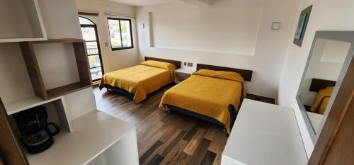 a small room with two beds and a mirror at Hotel Angeles in Ciudad Serdán
