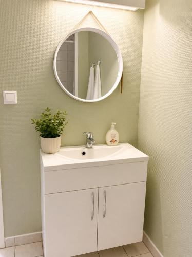 a bathroom with a white sink and a mirror at Jåsund SunView in Lyngdal