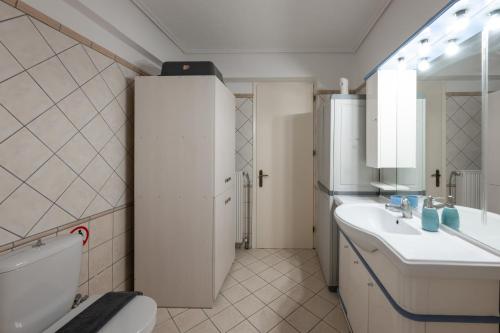 a bathroom with a toilet and a sink and a mirror at Makis Apartments in Tsoukalades