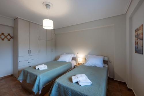 a bedroom with two beds with towels on them at Makis Apartments in Tsoukalades