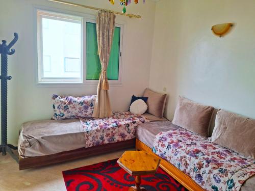 a living room with two beds and a couch at Palm beach in Mansouria in Ben Slimane