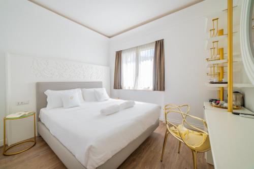 a white bedroom with a white bed and a window at Ciuri Taormina Maison de Charme in Taormina