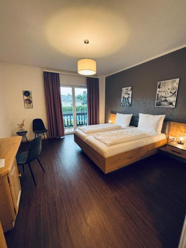 a bedroom with a bed and a desk and a window at Pension Hoogerland in Velden am Wörthersee