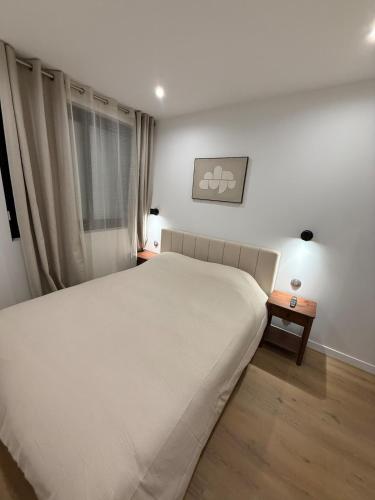a bedroom with a large bed and a window at Cocon de Montluçon in Montluçon