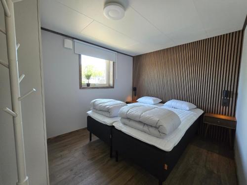 a bedroom with a large bed with pillows on it at Trellebystrands Camping in Lysekil