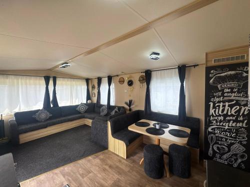 a living room with a couch and a table at Holiday Park Caravan Fluffy in Harts Holiday Park in Leysdown-on-Sea