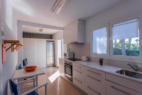 a kitchen with white cabinets and a sink at V206 Villa Isabel in Son Bou