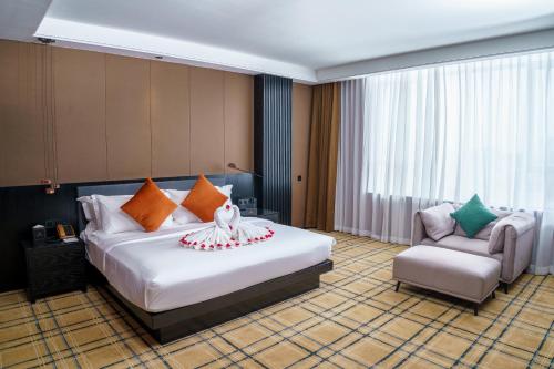 a hotel room with a bed and a chair at OCEAN HOTEL in Phnom Penh