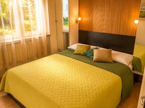 a bedroom with a large bed and two windows at Nido di Veronica See-Ferienwohnung in Bellano