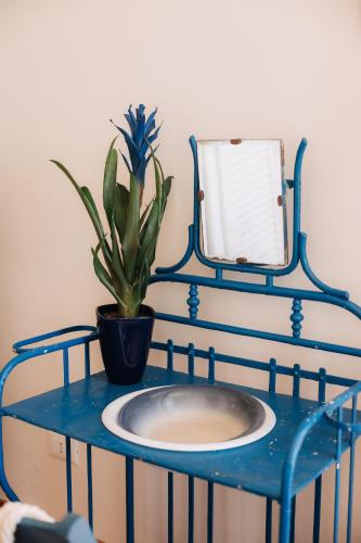 a blue table with a mirror and a potted plant at Villa Incina - Sea House in Polignano a Mare
