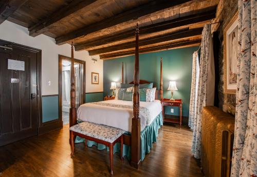 a bedroom with a canopy bed and a chair at Le Clos Saint-Louis - Par Aneyro in Quebec City