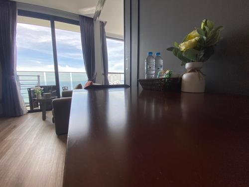 a living room with a table with a vase of flowers at Breath Taking View, Amazing Sea View Room in Pattaya South