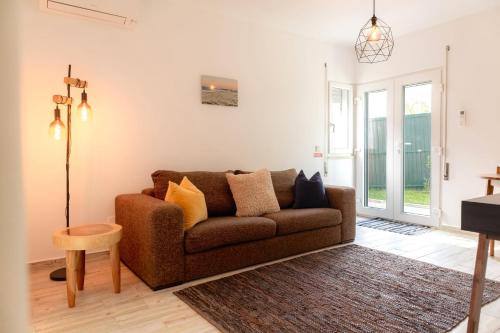 a living room with a brown couch and a table at 1bd Apartment close to beach in Lourinhã