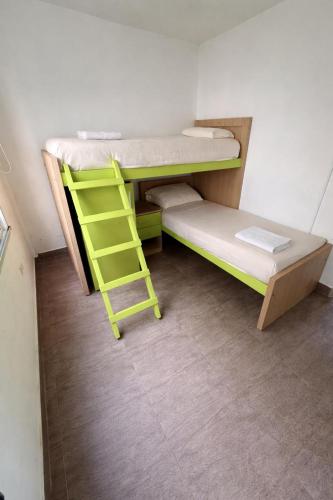 a bunk bed with a ladder in a room at Complejo del jaguel Cabaña Antuan Aires del bosque in Santa Teresita