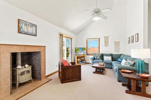 a living room with a blue couch and a fireplace at 8396 - White Dune in Avon