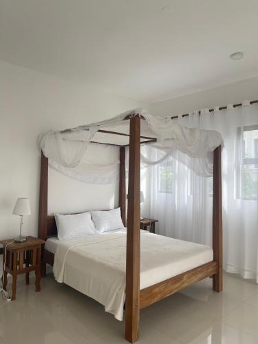 a bedroom with a canopy bed with white sheets at Villa in Vipingo in Vipingo