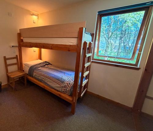 a bedroom with two bunk beds and a window at Newtonmore Hostel in Newtonmore