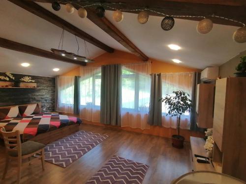 a bedroom with a bed and a couch and a table at къща за гости Горски чар in Beli Osŭm
