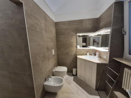a bathroom with a toilet and a sink and a mirror at Zia Nennè Holiday Rooms in Monopoli