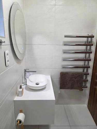 a white bathroom with a sink and a mirror at Random Villa in Révfülöp