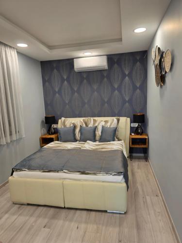 a bedroom with a large bed with blue pillows at Random Villa in Révfülöp