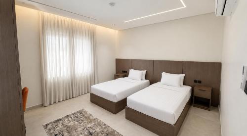 a hotel room with two beds and a window at OrbitNet - Anwarat in Medina
