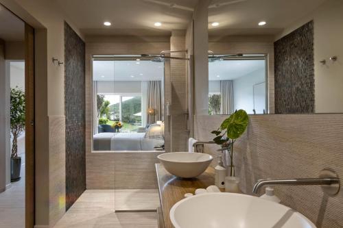 a bathroom with a sink and a mirror at L'Ea Bianca Luxury Resort in Baja Sardinia