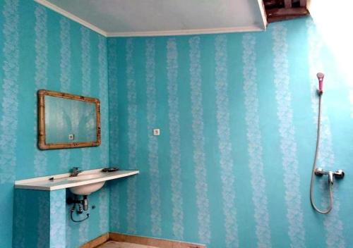 a bathroom with a sink and a mirror on the wall at Hotel Besar Bulan Baru Senggigi - Near Senggigi Beach in Senggigi