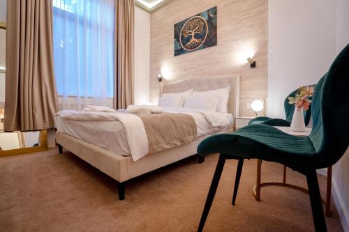 a bedroom with a large bed and a green chair at Luna Boutique in Bucharest