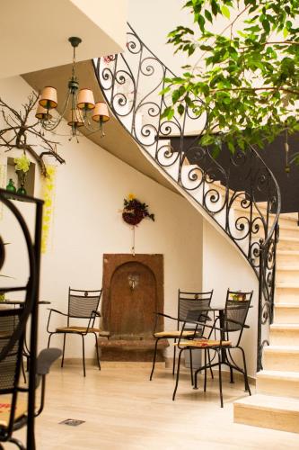a staircase with chairs and a table and a fireplace at Borbarátok Háza in Győr