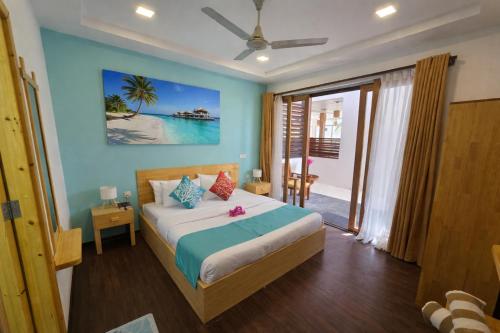 a bedroom with a bed with a blue wall at Dhiffushi Reef & Beach in Dhiffushi
