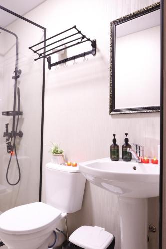 a bathroom with a sink and a toilet and a mirror at AL-BUKHARI Boutique Hostel in Bukhara