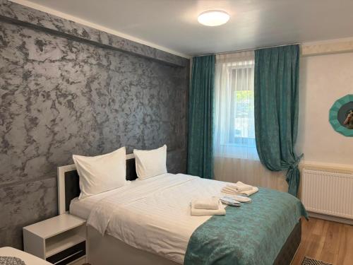 a bedroom with a bed with two towels on it at Grey Boutique Hotel Palas in Iaşi