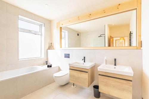 a bathroom with a sink and a toilet and a mirror at Spacious Central Harrogate Retreat in Harrogate