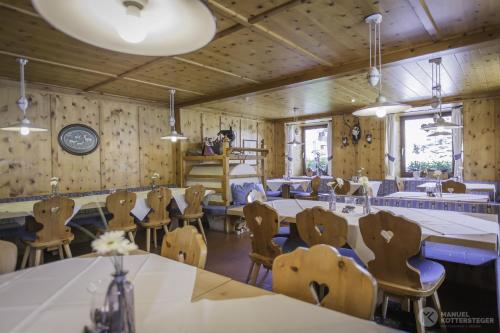 Pokój z drewnianymi ścianami, stołami i krzesłami w obiekcie Berghotel Kason w mieście Predoi
