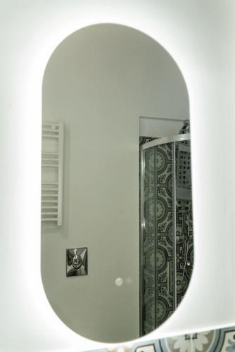 a mirror in a white room with a bathroom at torre poesia in Trani