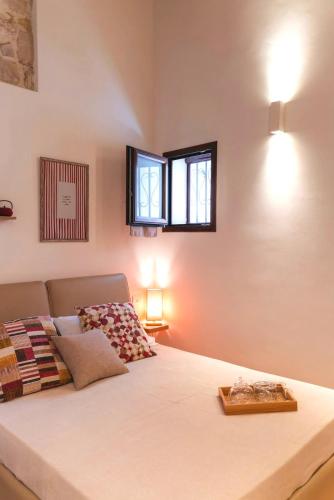 a bedroom with a large white bed with two windows at torre poesia in Trani