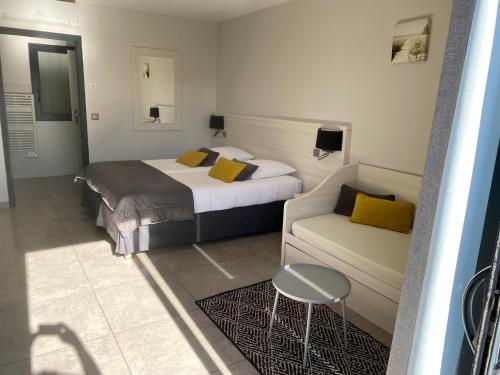a hotel room with a bed and a couch at Les studios du Centre in La Teste-de-Buch